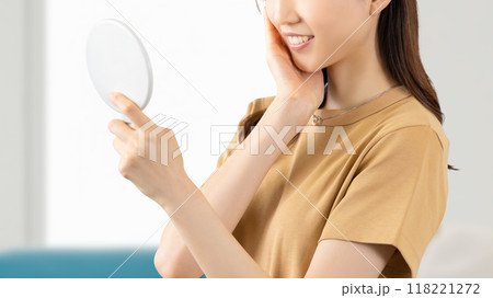 鏡で肌をチェックする若い女性 鏡で肌をチェックする若い女性 118221272