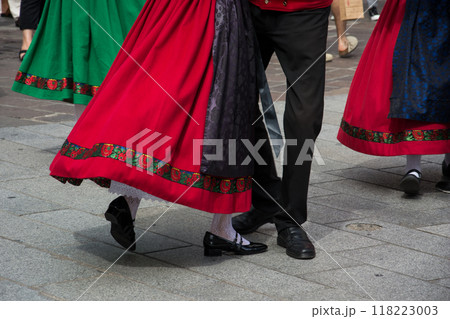 Closeup of legs of traditional alsatian dancers with colorful costume dancing in the street 118223003