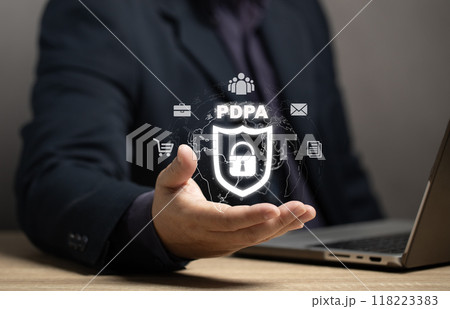 Man holding a security shield icon with a padlock in the middle. Concept of Personal Data Protection Act: PDPA. It is a legal principle to prevent the violation of personal data of everyone. Man holding a security shield icon with a padlock in the middle. Concept of Personal Data Protection Act: PDPA. It is a legal principle to prevent the violation of personal data of everyone. 118223383