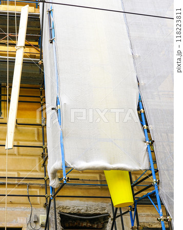 House restoration using metal tube scaffolding and plastic debris pipe covered with safety mesh 118223811