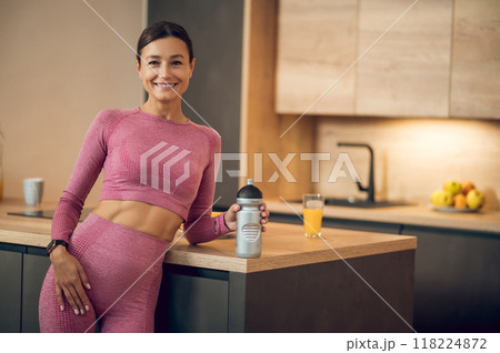 Athletic woman in sportswear drinking protein shake or bottle of water 118224872