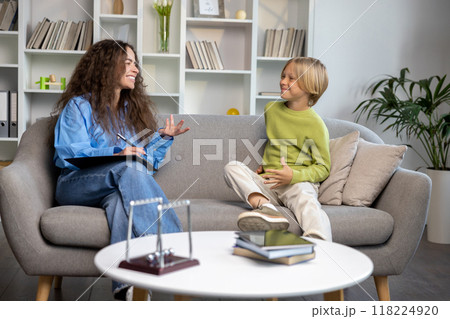 Long-haired woman talking to a blonde boy and both looking involved 118224920