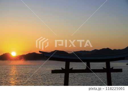 夜明けの瀬戸内流れる海霧と海に建つ鳥居と朝日 夜明けの瀬戸内流れる海霧と海に建つ鳥居と朝日 118225001