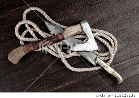 small axe with bowie knife and rope on wooden table 118225135