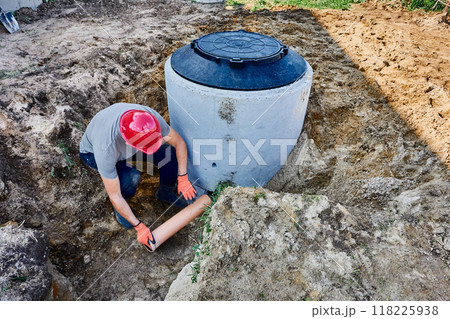 Connecting septic tank to external disposal system, installing out-flowing pipe through which wastewater will flow into leach field. 118225938