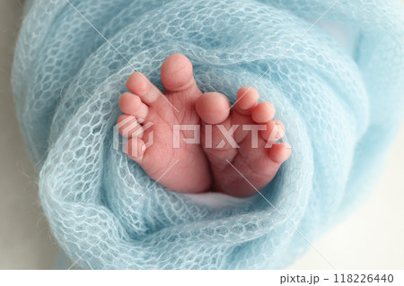 Close-up of tiny, cute, bare toes, heels and feet of a newborn girl, boy. Baby foot on blue soft coverlet, blanket. Detail of a newborn baby legs. Macro horizontal professional studio photo.  118226440