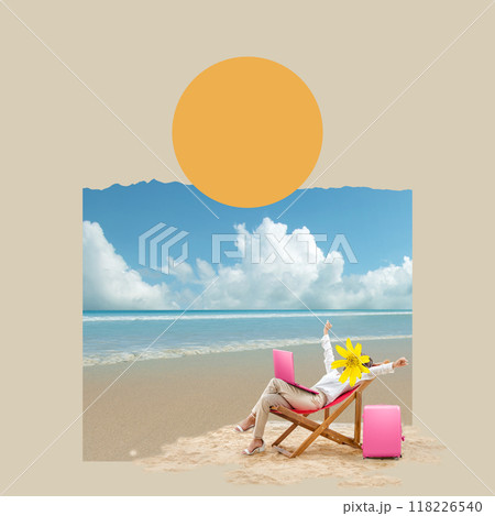 A woman is sitting on a beach chair with a laptop in front of her 118226540