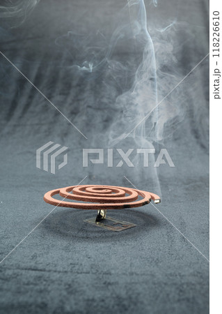 A mosquito coil with smoke coming out of it A mosquito coil with smoke coming out of it 118226610
