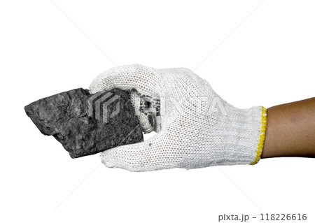A person is holding a handful of coal in their gloved hands 118226616