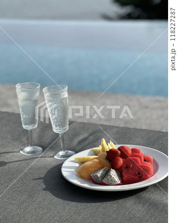 フルーツを食べながらプールサイドでくつろぐ フルーツを食べながらプールサイドでくつろぐ 118227287