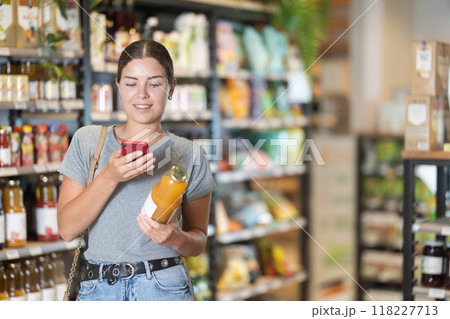 Young woman in supermarket scan QR code on bottle of drink Young woman in supermarket scan QR code on bottle of drink 118227713