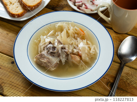 Fragrant cabbage soup with pork rib. Dish is complemented with plate of bacon and bread. 118227813