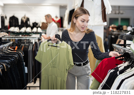 Young woman choosing dress in clothing store Young woman choosing dress in clothing store 118227831