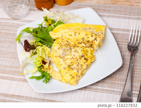 Delicious omelet with arugula on white plate Delicious omelet with arugula on white plate 118227832