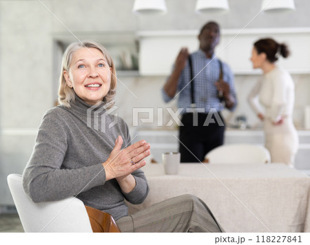Elderly woman smiling during family quarrel 118227841