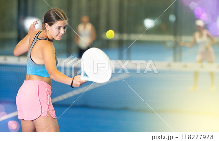 Portrait of girl paddle tennis player during friendly doubles couple match at court Portrait of girl paddle tennis player during friendly doubles couple match at court 118227928