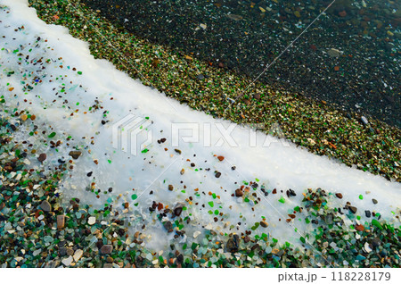 Multi-colored glass on the ice and snow of Japanese sea. Glass beach, Russia 118228179