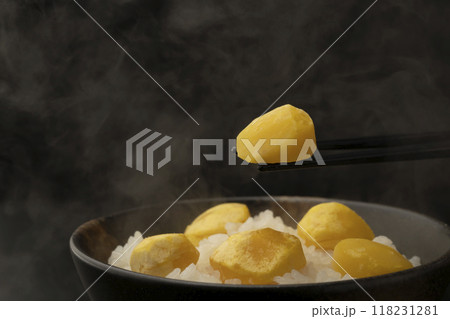 栗ご飯　茶碗に盛り付けた栗ご飯を箸で持ち上げる 118231281