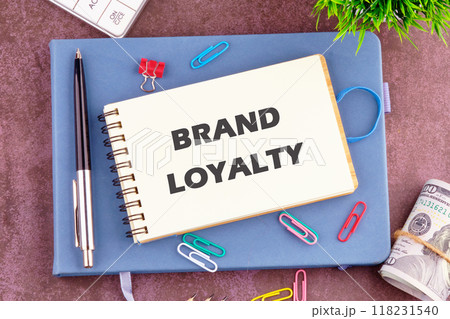 Conceptual brand loyalty symbol. Copy space. BRAND LOYALTY in a notebook in a composition with office supplies, top view 118231540