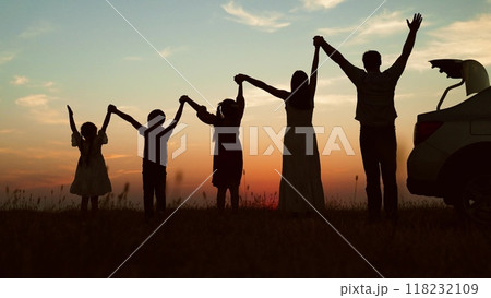 Big family at sunset holding hands, silhouettes. Happy people children parents lined up according to height held hands raised in air with joyful cheerful feeling of freedom anticipation of journey. Big family at sunset holding hands, silhouettes. Happy people children parents lined up according to height held hands raised in air with joyful cheerful feeling of freedom anticipation of journey. 118232109