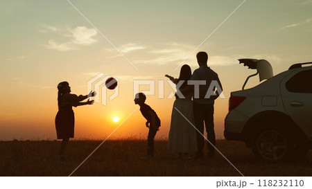 Family at sunset by car in field silhouettes. Children kids plays ball parents hugging enjoying romantic atmosphere happy moment. Importance of Spending Time Together Creating Lasting Family Memories Family at sunset by car in field silhouettes. Children kids plays ball parents hugging enjoying romantic atmosphere happy moment. Importance of Spending Time Together Creating Lasting Family Memories 118232110