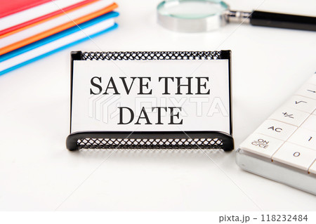 SAVE THE DATE words on a business card in a composition with a magnifying glass, notebooks, a calculator on a white background SAVE THE DATE words on a business card in a composition with a magnifying glass, notebooks, a calculator on a white background 118232484