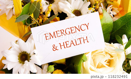 EMERGENCY and HEALTH written on a white business card, close-up on a background of flowers 118232491