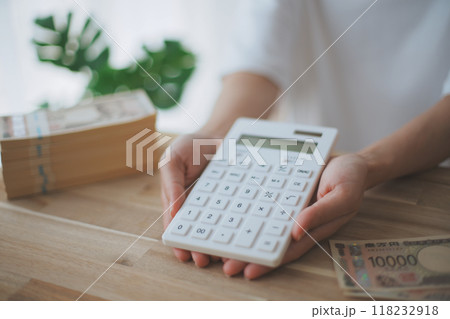 お金と電卓を持つ女性の手元 118232918