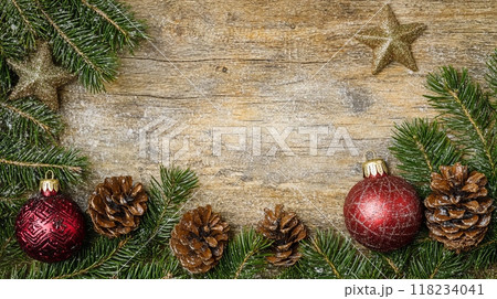 Festive Christmas ornaments and pine branches on a rustic wooden background. 118234041