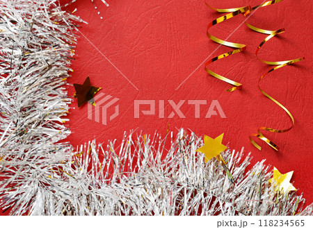 White holiday tinsel and golden scrolled ribbon on red paper White holiday tinsel and golden scrolled ribbon on red paper 118234565