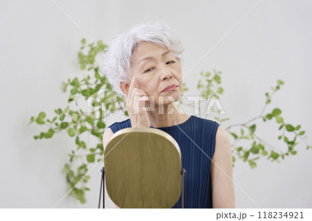 目尻のシワに悩む高齢者の女性 118234921
