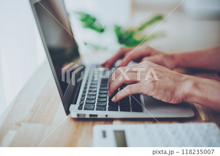 ノートパソコンで仕事をする女性の手元 118235007