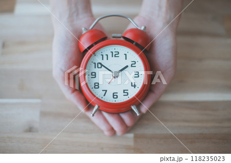 目覚まし時計を持つ女性の手元 目覚まし時計を持つ女性の手元 118235023