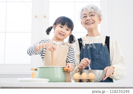 キッチンに立つ女の子とシニア女性 料理イメージ キッチンに立つ女の子とシニア女性 料理イメージ 118235295
