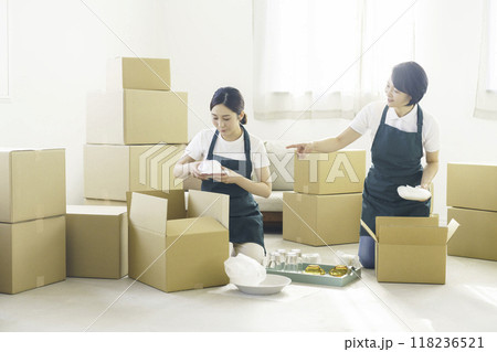 引越し作業をする女性引越し業者2人 引越し作業をする女性引越し業者2人 118236521