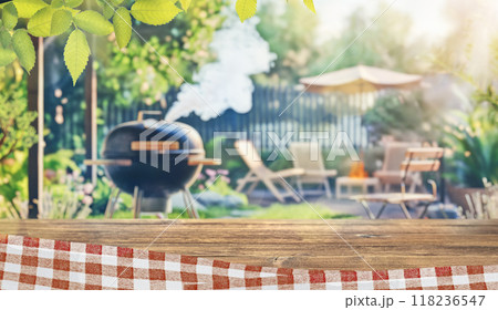 summer time party in backyard garden with grill BBQ, wooden table, blurred background 118236547