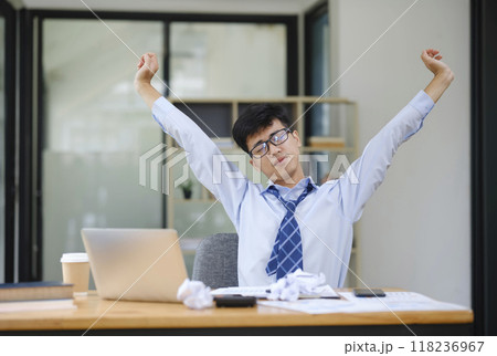 Businessman Stretching at Desk to Relieve Stress from Work 118236967