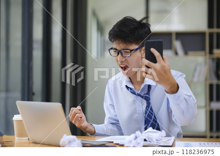 Frustrated Businessman Yelling at Laptop in Anger Frustrated Businessman Yelling at Laptop in Anger 118236975