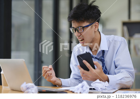 Frustrated Businessman Yelling at Laptop in Anger Frustrated Businessman Yelling at Laptop in Anger 118236976