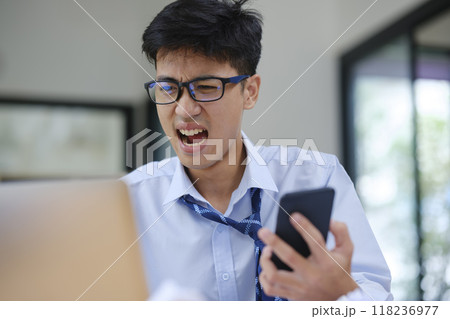 Frustrated Businessman Yelling at Laptop in Anger Frustrated Businessman Yelling at Laptop in Anger 118236977