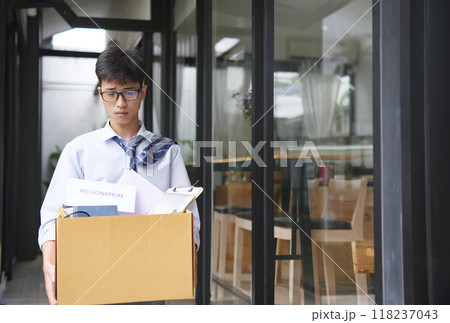 Businessman Leaving Office After Resignation with Box of Belongings Businessman Leaving Office After Resignation with Box of Belongings 118237043