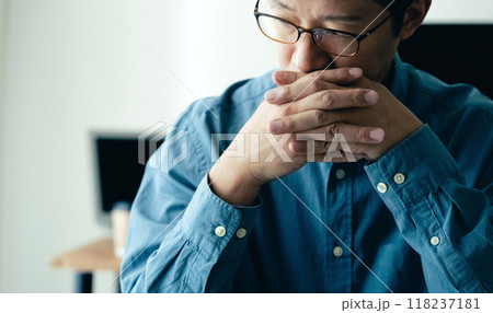 パソコンの前で悩む男性 118237181