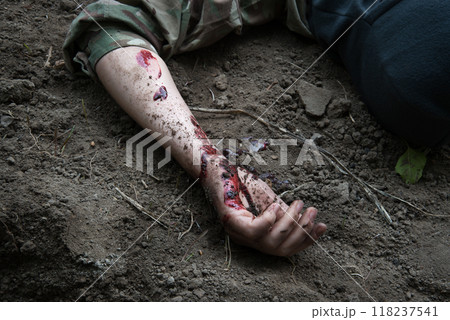 Hand of a wounded soldier on the ground 118237541