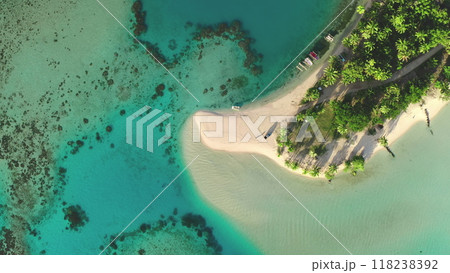 Aerial view top down small tropical island with palm trees and white sand beach surrounded by turquoise ocean water and coral reef. Remote wild nature paradise, exotic summer luxury travel. Drone shot Aerial view top down small tropical island with palm trees and white sand beach surrounded by turquoise ocean water and coral reef. Remote wild nature paradise, exotic summer luxury travel. Drone shot 118238392
