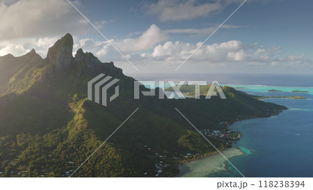 Golden sunlight over iconic mountain peak and turquoise lagoons of Bora Bora tropical island, dramatic beauty of French Polynesian paradise. Remote wild nature scene, travel background. Aerial view Golden sunlight over iconic mountain peak and turquoise lagoons of Bora Bora tropical island, dramatic beauty of French Polynesian paradise. Remote wild nature scene, travel background. Aerial view 118238394