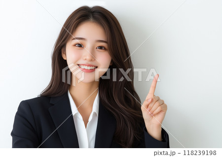 AI生成画像　白背景の人差し指を立ててポーズをする若いビジネスウーマンのポートレート 118239198
