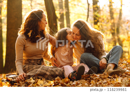 The homosexual family playing with her daughter in the autumn forest. The adventure is more fun. The homosexual family playing with her daughter in the autumn forest. The adventure is more fun. 118239981