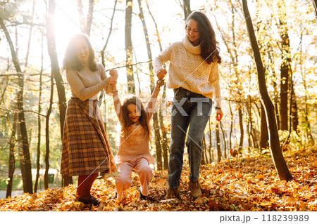 The homosexual family playing with her daughter in the autumn forest. The adventure is more fun. The homosexual family playing with her daughter in the autumn forest. The adventure is more fun. 118239989