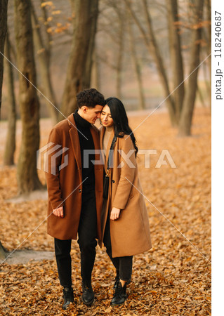 Young couple in love walking in the park on a autumn day. Enjoying time together. Young couple in love walking in the park on a autumn day. Enjoying time together. 118240687