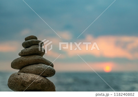 Stone Cairns Beach Ocean - Three stone cairns stacked on a sandy beach by the ocean. 118240802